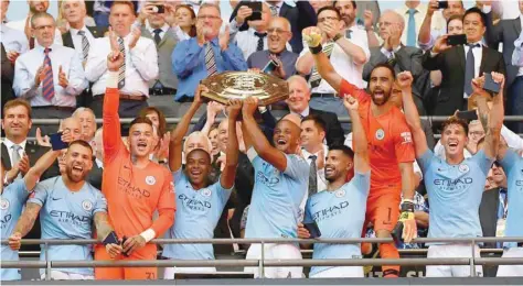  ?? — Reuters ?? Manchester City players celebrate with the trophy after the Community Shield match.