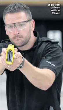  ??  ?? A police officer with a Taser