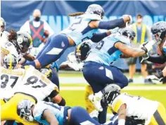  ?? AP PHOTO/ MARK ZALESKI ?? Tennessee Titans running back Derrick Henry, top, dives over the goal line for a touchdown against the Pittsburgh Steelers on Sunday in Nashville. The Steelers won 27-24 to reach 6-0, handing the Titans their first loss of the season.