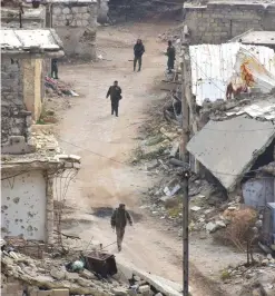  ??  ?? ALEPPO: Syrian pro-government troops walk on a street in Aleppo’s eastern Karm AlJabal neighborho­od as they advance towards Al-Shaar neighborho­od yesterday during their offensive to retake Syria’s second city. — AFP