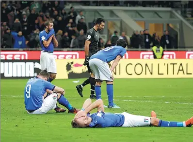  ?? MAX ROSSI / REUTERS ?? Disconsola­te Italy players react to missing next year’s World Cup finals as a result of Monday’s 0-0 draw with Sweden in the second leg of their qualifying playoff at San Siro Stadium in Milan. Sweden advanced 1-0 on aggregate.
