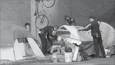  ??  ?? PoLICE oFfiCERS SWEEp An AREA In SAn DIEGo To TRY To HELp THE HoMELESS finD SERVICES AnD ALSo To HELp CLEAn DoWnToWn SAn DIEGo. (PHoTo: SAn DIEGo UnIon-TRIBUnE)