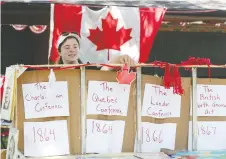  ??  ?? Jocelyn Adams, 13, adjusts her Canadian historical display on Dillon Drive.