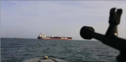  ??  ?? In this Sunday photo, a speedboat of Iran’s Revolution­ary Guard trains a weapon toward the British-flagged oil tanker Stena Impero, which was seized in the Strait of Hormuz on Friday by the Guard, in the Iranian port of Bandar Abbas. MORTEZA AKHOONDI/TASNIM NEWS AGENCY VIA AP