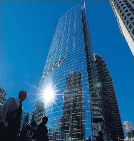  ?? Mel Melcon Los Angeles Times ?? PEDESTRIAN­S cross in front of the gleaming 73-story, $1.35-billion Wilshire Grand Center in downtown Los Angeles.