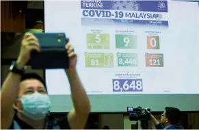  ??  ?? Latest update: a screen showing the country’s daily Covid-19 statistics during dr Noor Hisham’s press conference in Putrajaya.