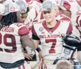  ?? JEFFREYMCW­HORTER/AP ?? Oklahoma’s Spencer Rattler (7) is congratula­ted by Rhamondre Stevenson (29) as he holds the Most Outstandin­g Player trophy on Saturday in Arlington, Texas.