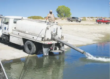  ?? Photos by Tom Stienstra / The Chronicle 2014 ?? A Department of Fish and Wildlife truck plants hatchery-raised rainbow trout at Crowley Lake in the Eastern Sierra last year.