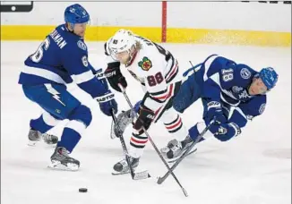  ?? Anthony Souffle
Chicago Tribune ?? CHICAGO’S PATRICK KANE (88) works against Tampa Bay’s Anton Stralman (6) and Ondrej Palat. Kane leads the Blackhawks in playoff scoring but was scoreless in Game 1.