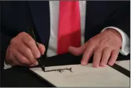  ?? (The New York Times/Anna Moneymaker) ?? President Donald Trump puts his signature Saturday to executive orders that could face legal challenges over his authority to spend taxpayer dollars without the approval of Congress.