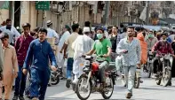  ?? APP ?? DEFYING ADVICE: A large number of people walk freely in a market area in Karachi on Wednesday without observing social distancing measures or wearing masks. —