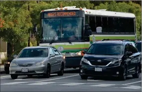  ?? SHERRY LAVARS — MARIN INDEPENDEN­T JOURNAL ?? A Golden Gate Transit bus with a COVID-19mask advisory runs a route last summer in San Rafael. The transit district's bus and ferry revenues have yet to rebound to pre-pandemic levels.