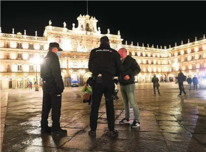  ?? EFE ?? Dos agentes de Policía Nacional y un ciudadano, en la Plaza Mayor de Salamanca