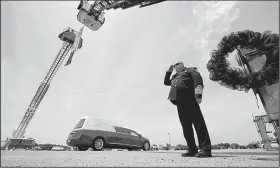  ?? Arkansas Democrat-Gazette/STATON BREIDENTHA­L ?? Batesville Fire Chief Brent Gleghorn salutes Friday in Newport as the hearse carrying Newport police Lt. Patrick Weatherfor­d passes under a flag hung between ladder trucks from the Batesville and Newport fire department­s.