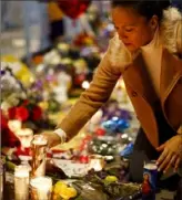  ?? Assiciated press ?? Angelica Diaz places a candle Tuesday at a memorial for Kobe Bryant near Staples Center in Los Angeles.