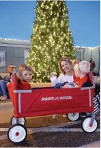  ??  ?? ■ Caitlyn Trim has just the right vehicle for her sons Cameron, left, and Cooper to ride in the Christmas parade.