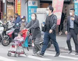  ?? CHIANG YING-YING/AP ?? Pedestrian­s wear masks Wednesday to help protect against the spread of COVID-19 in Taipei, Taiwan. Wearing a face mask is near universal in major cities in Taiwan.