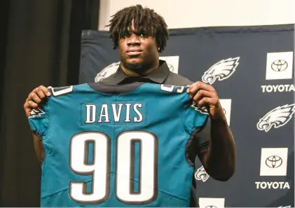  ?? STEVEN M. FALK/AP ?? Jordan Davis, a Philadelph­ia Eagles first-round draft pick, holds his jersey during a news conference at the team’s practice facility Friday in Philadelph­ia.