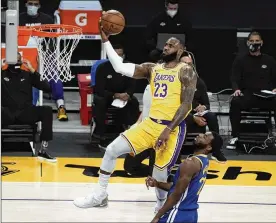  ?? JAE C. HONG / ASSOCIATED PRESS ?? The Los Angeles Lakers’ LeBron James goes up for a basket as the Golden State Warriors’ Andrew Wiggins watches Jan. 18 in Los Angeles.