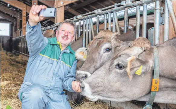  ?? FOTO: HANS-RUDOLF SCHULZ ?? Ein Selfie mit dem Rindvieh: Franz Kinker, der bloggende Biobauer aus Roßhaupten im Allgäu, nutzt die neuen Medien gezielt, um den Menschen seine tägliche Arbeit näher zu bringen – und damit zu zeigen, dass landwirtsc­haftliche Produkte mehr wert sind,...