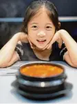  ??  ?? Dieses Mädchen sitzt gerade vor einer Kimchi Suppe.