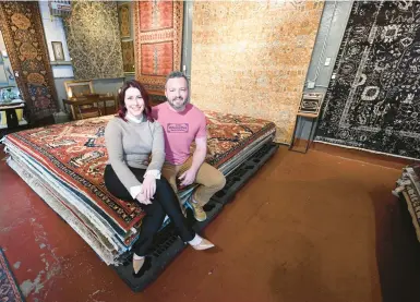  ?? AMY SHORTELL/THE MORNING CALL PHOTOS ?? Dee Ward and Matt Geist, co-owners of Ward’s Oriental Rug Service and Gallery, sit on some of their wares at the business in Allentown on Friday.