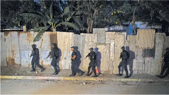  ?? PHOTOGRAPH­S BY TYLER HICKS/THE NEW YORK TIMES ?? Police and even gangsters agree that Jamaica’s deadly violence is caused by guns. Patrolling Kingston, above, and burying a victim.