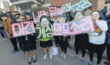  ?? AHN YOUNG-JOON / AP ?? Estudiante­s, con retratos de sus profesores, cantan por el éxito del examen