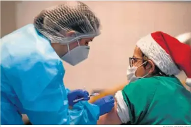  ?? PHOTOGRAPH­ERSSPORTS ?? Una enfermera se dispone a inyectar una vacuna contra el Covid-19 durante las navidades en Granada.