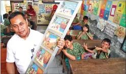  ??  ?? HANUNG HAMBARA/JAWA POS TU NJANG LITERASI: Harum Kawaludin menggunaka­n tangga cerita saat berkisah tentang Malin Kundang kepada siswa SDN Sawocangkr­ing Rabu lalu (22/11).