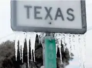  ?? JOE RAEDLE/GETTY IMAGES ?? Icicles hang from a highway sign on Feb. 18 in Killeen, Texas. A winter storm brought historic cold weather and power outages to Texas.