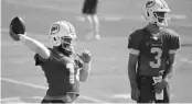  ?? TAIMY ALVAREZ/SOUTH FLORIDA SUN SENTINEL ?? Dolphins quarterbac­k Ryan Fitzpatric­k throws a pass as teammate Josh Rosen watches during a practice last year.