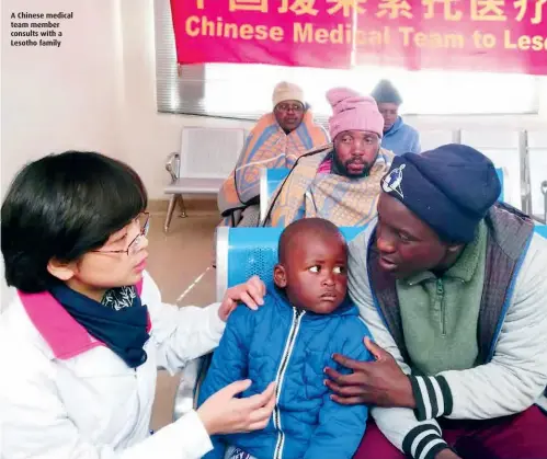  ??  ?? A Chinese medical team member consults with a Lesotho family