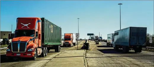  ?? MERIDITH KOHUT / NEW YORK TIMES ?? Trucks cross the Rio Grande between Laredo, Texas, and Nuevo Laredo, Mexico. A new trade agreement between the United States, Canada and Mexico may be a bright spot in an otherwise dysfunctio­nal dynamic that has taken hold in Washington, and it owes its progress to a coincidenc­e of timing and political necessity.