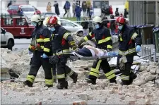  ?? THE ASSOCIATED PRESS ?? Firefighte­rs carry a person on a stretcher after an earthquake in Zagreb, Croatia, Sunday, March 22, 2020. A strong earthquake shook Croatia and its capital on Sunday, causing widespread damage and panic.