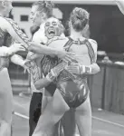  ?? BRYAN TERRY/THE OKLAHOMAN ?? Oklahoma’s Olivia Trautman, center, celebrates after scoring a perfect 10 on the vault in a March 3 meet.