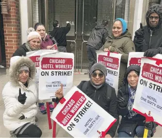  ?? UNITE HERE LOCAL 1 ?? Striking members of Unite Here Local 1 assemble Monday outside the hotel at 166 E. Superior as a worker scrapes the Cambria name off a door.