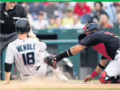  ?? ALEX BRANDON AP ?? The Marlins’ Joey Wendle slides home Friday night before the Nationals’ Keibert Ruiz can make the tag. Wendle had driven in the Marlins’ second run before Garrett Cooper drove him in with a double to give the Marlins a 3-0 lead in the third inning.