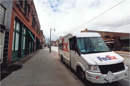  ?? JOE RONDONE/THE COMMERCIAL APPEAL ?? A Fedex truck delivers packages along South Main Street as one of the essential businesses during the coronaviru­s pandemic in March.