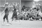  ?? [PHOTO BY BRYAN TERRY, THE OKLAHOMAN] ?? Newcastle’s Kennedy Cook, left, and Maebree Robertson walk off the field while Tuttle celebrates winning the Class 4A state fastpitch softball championsh­ip Wednesday in Shawnee.