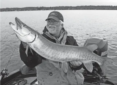  ?? PAUL A. SMITH / MILWAUKEE JOURNAL SENTINEL ?? Mike Koepp of Pewaukee smiles as he displays a 40-inch musky caught on Pewaukee Lake on Dec. 3. The fish was then released.