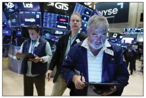  ?? (AP/Richard Drew) ?? A trio of traders work on the floor of the New York Stock Exchange on Friday.