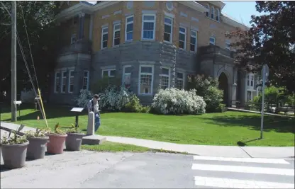  ?? The Associated Press ?? A border post and planters show the U.S.-Canadian border where it leads to the Haskell Opera House and library, a building located in the two countries. Brian and Joan Dumoulin, from the nearby neighborho­od of Beebe Plain, say they’re having a hard...