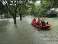  ?? CHARLIE RIEDEL — THE ASSOCIATED PRESS ?? A Coast Guard rescue team evacuates people from a neighborho­od inundated by floodwater­s from Tropical Storm Harvey on Monday in Houston, Texas.