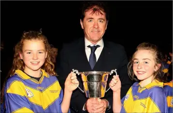  ??  ?? Jim Dempsey presents the cup to joint Taghmon captains Lily Sidney-Kinsella and Emily Roche.