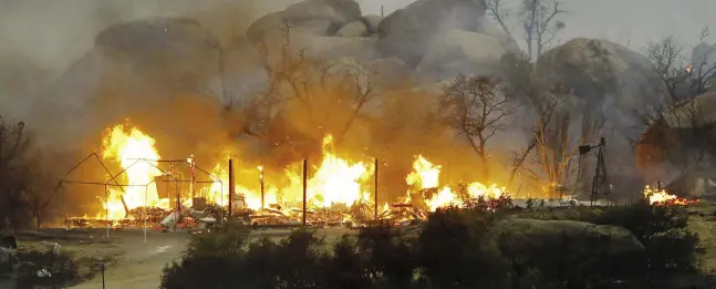  ?? DAVID KADLUBOWSK­I / THE ASSOCIATED PRESS ?? Homes burn near Yarnell, Ariz., on Sunday, the day of the tragedy. Some residents watched their homes burn on live television.