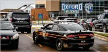  ?? NICK HAGEN/THE NEW YORK TIMES ?? Law enforcemen­t officials patrol outside Oxford High School in Michigan last week after four students were killed on campus, allegedly by a fellow student.