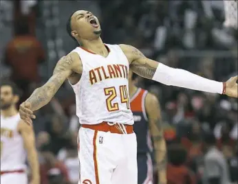  ?? Curtis Compton/Atlanta Journal-Constituti­on ?? Atlanta’s' Kent Bazemore adds an exclamatio­n mark to a basket Saturday in the Hawks’ 116-98 rout of Washington in Atlanta.