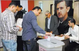  ??  ?? The Associated Press Syrians cast their votes at a polling station during municipal elections Sunday in Damascus, Syria.