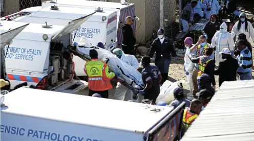  ?? Picture: Mark Andrews ?? Forensics experts load the bodies of some of the teenagers who died at the Enyobeni tavern on the Sunday morning after the tragedy.